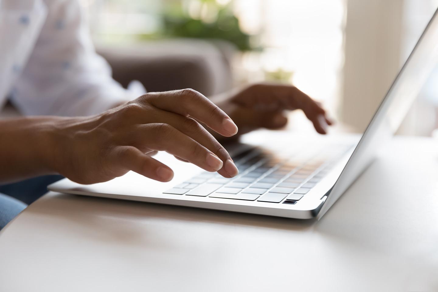 hands typing on laptop