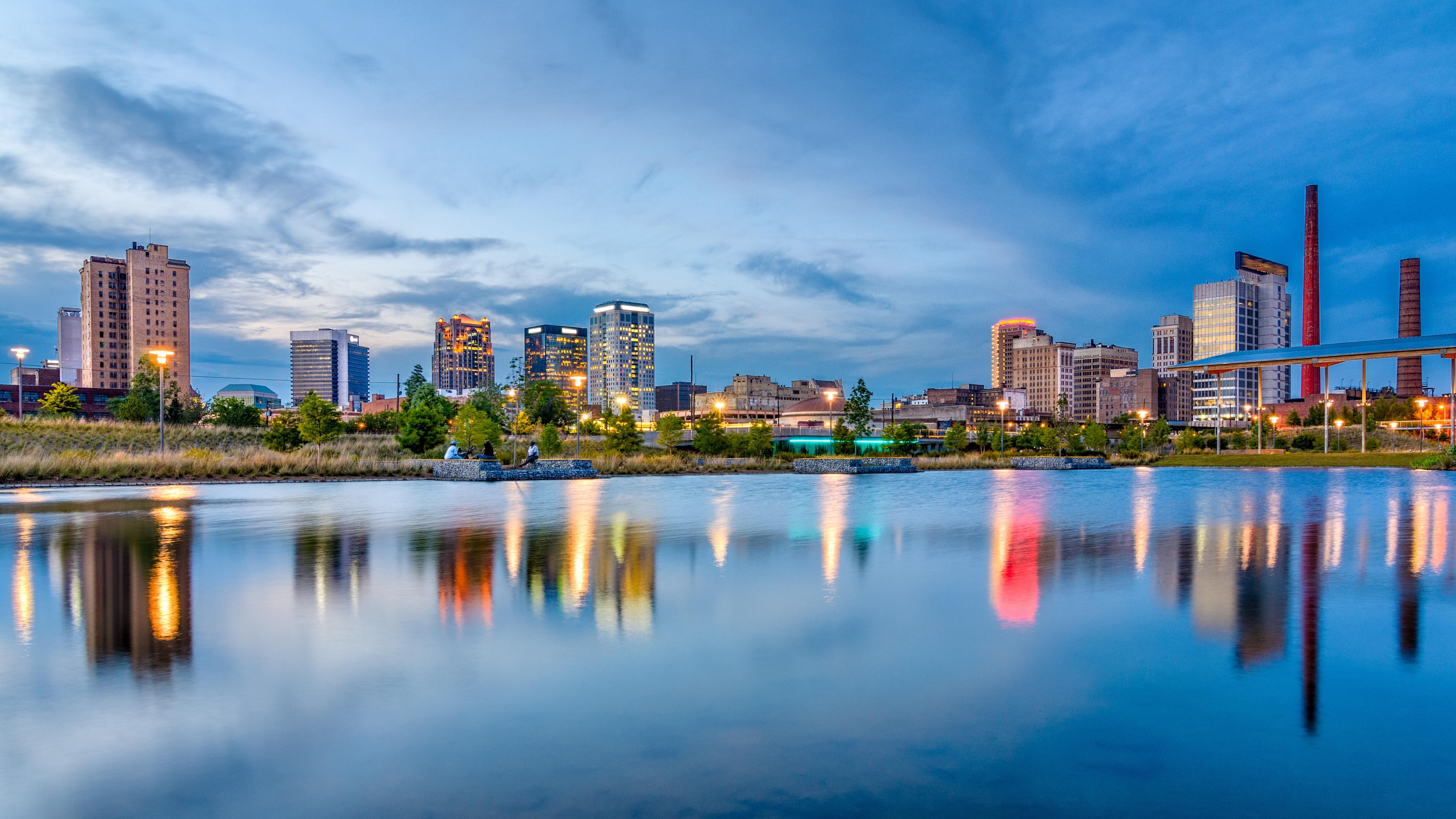 Birmingham, Alabama skyline against a lake at dusk