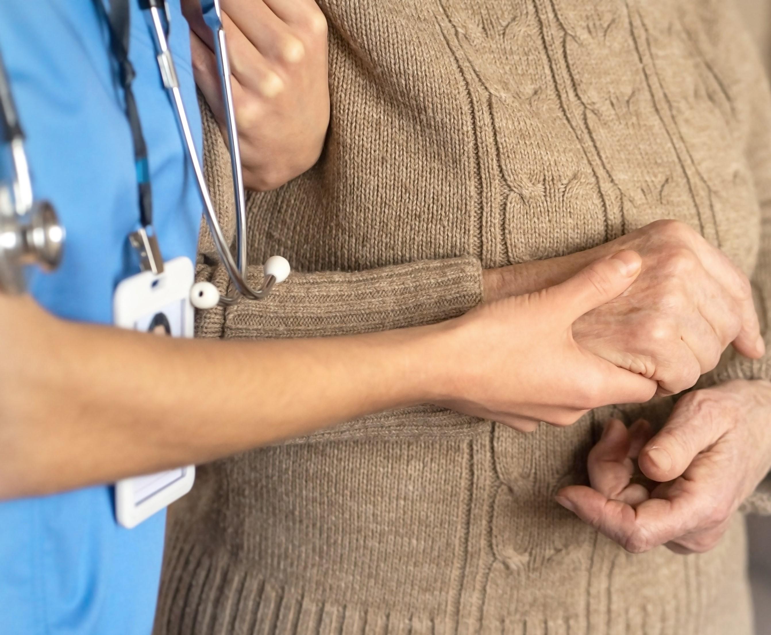 Nurse holding the hand of an elderly person